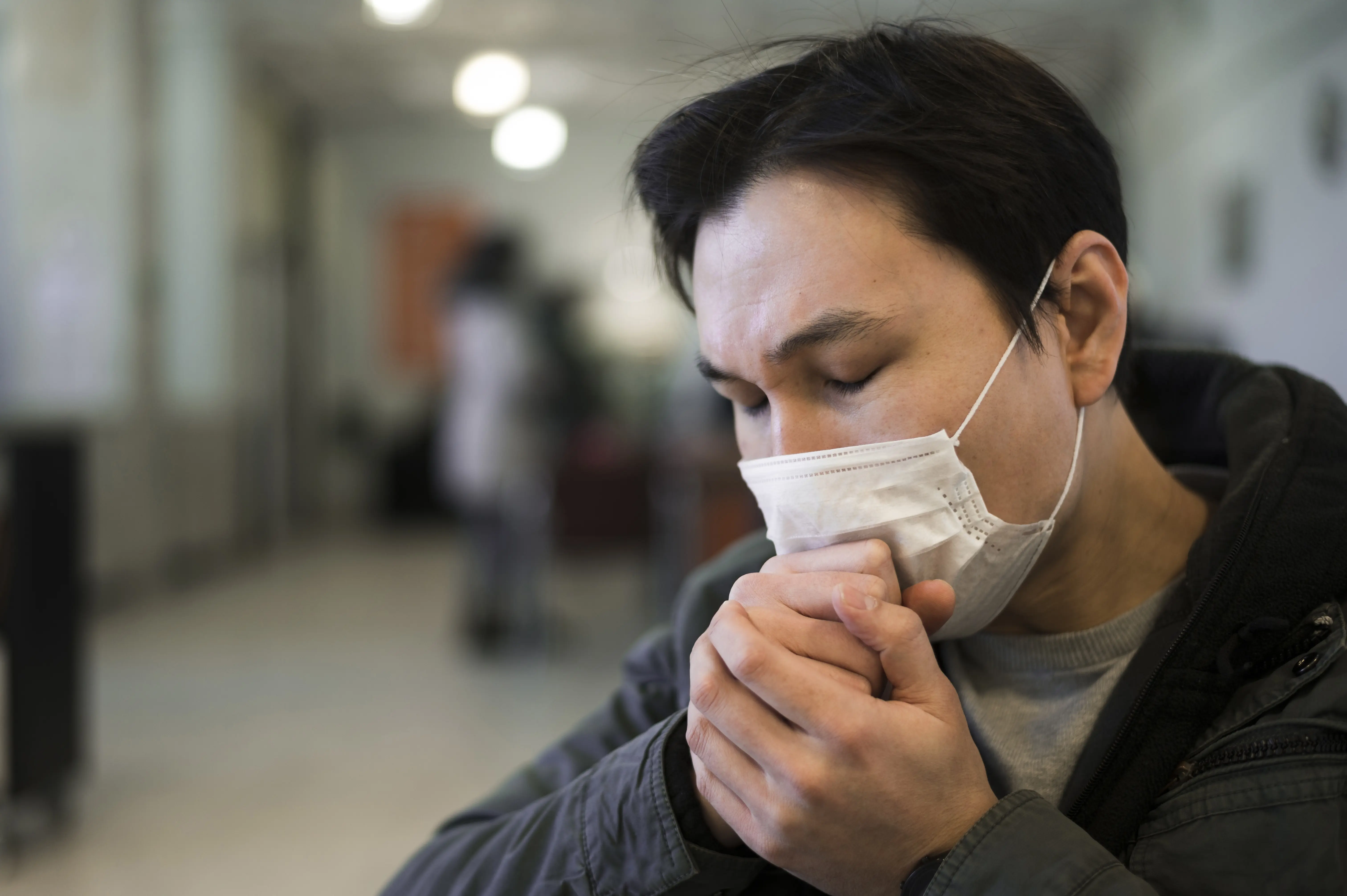 Person wearing a medical mask looking down